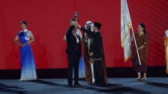 Gubernur DKI Jakarta Anies Baswedan menyerahkan obor saat penutupan Asian Games di GBK, Jakarta, Minggu (2/9). (Foto: Fanny Kusumawardhani/kumparan)