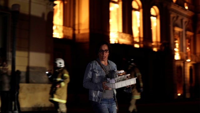 Petugas menyelamatkan barang-barang saat kebakaran di Museum Nasional Brasil di Rio de Janeiro, Brasil 2 September 2018. (Foto: REUTERS / Ricardo Moraes)