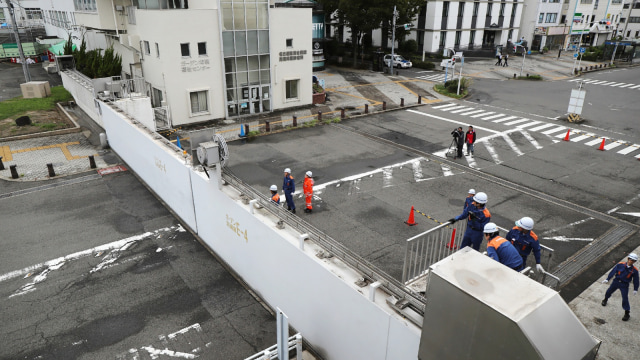 Petugas pelabuhan Nagoya menutup gerbang pemecah gelombang di Nagoya pada, Selasa (4/9/2018). (Foto: JIJI PRESS/AFP)