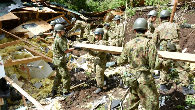 Anggota Pasukan Bela Diri Jepang (JSDF) mengevakuasi korban gempa bumi di kota Atsuma, Hokkaido, Jepang utara. (Foto: Japan Self-Defense Forces/Handout via Reuters)