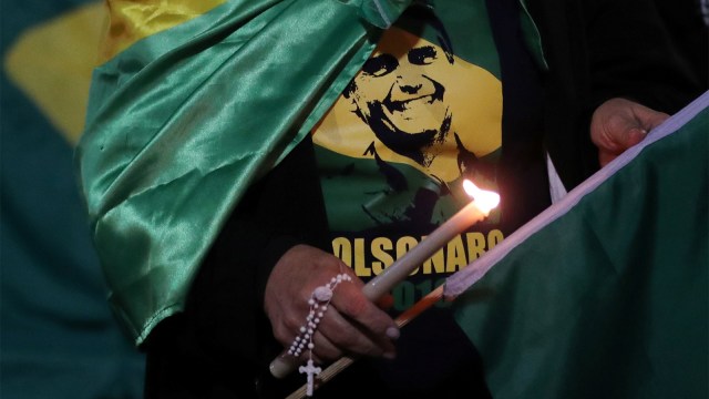 Seorang pendukung menyalakan lilin untuk mendoakan calon presiden Brasil, Jair Bolsonaro yang dirawat usai ditikam di Juiz de Fora, Brasil. (Foto: REUTERS/Paulo Whitaker)