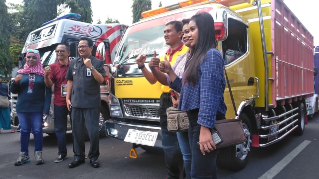 Peserta dan pengunjung berfoto depan truk modifikasi saat Jogjakarta Truck Festival 2018 di Jogja Expo Center (JEC) dengan start di Kantor Walikota Yogyakarta, Jumat  (07/09/2018). (Foto: Arfiansyah Panji Purnandaru/kumparan)