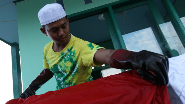 Salah satu santri mewarnai kain dengan teknik Sasirangan (Foto: Iqbal Firdaus/kumparan)