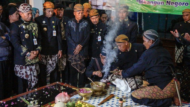 Bupati Batang Wihaji (kedua kiri) mengamati ritual membersihkan ujung Tombak Abirawa saat mengikuti tradisi Jamasan Pusaka di Kabupaten Batang, Jawa Tengah. Foto: Antara/Harviyan Perdana Putra