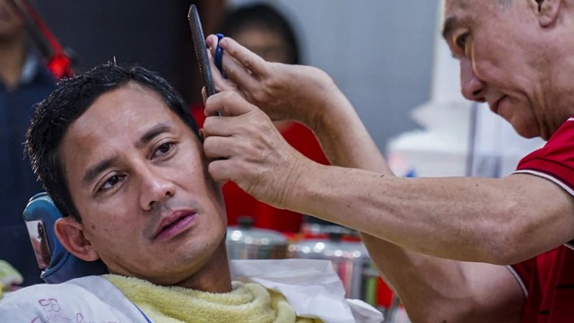 Bakal calon Wakil Presiden Sandiaga Uno memotong rambut di pangkas rambut Ko Tang, Glodok, Jakarta, Selasa (11/9/2018). (Foto: ANTARA FOTO/Bimasurya Eka Putra)