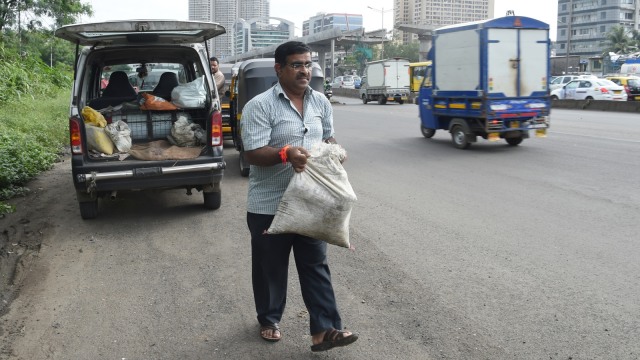 Dadarao Bilhore saat akan menambal lubang jalanan di India. (Foto: AFP/INDRANIL MUKHERJEE )