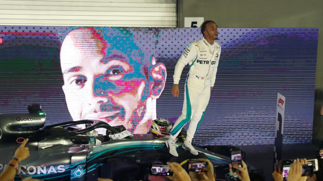 Lewis Hamilton merayakan kemenangannya di GP Singapura. (Foto: REUTERS/Edgar Su)