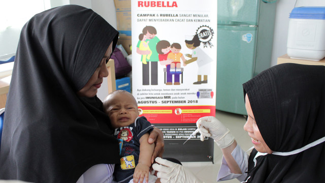 Petugas menyuntikan Vaksin Campak dan Rubella (MR) kepada bayi saat dilakukan imunisasi. Foto: ANTARA FOTO/Ampelsa