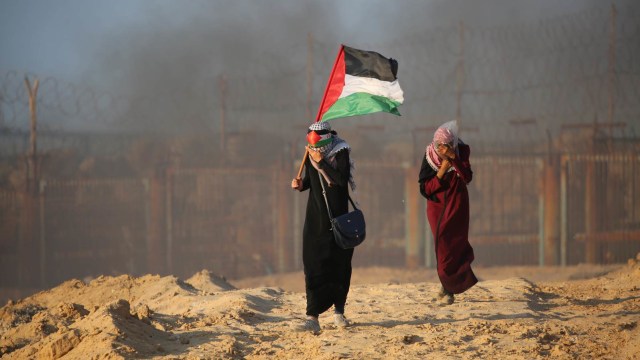 Seorang wanita memegang bendera Palestina saat demonstrasi di Gaza. (Foto: AFP/Said Khatib)