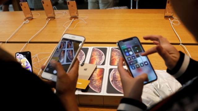 Pelanggan dari Vietnam mengambil foto pembelian iPhone XS mereka di Apple Store di Singapura (Foto: REUTERS/Edgar Su)