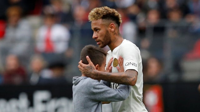 Neymar memeluk bocah yang menginvasi lapangan saat laga Rennes vs Paris Saint-Germain. (Foto: Stephane Mahe/Reuters)