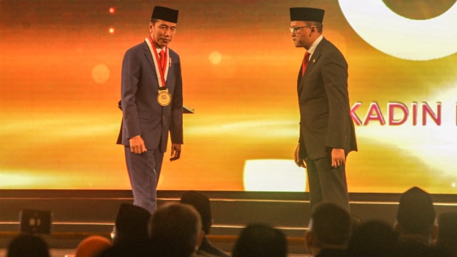 Presiden Joko Widodo (kiri) menerima penghargaan dari Ketua Umum Kadin Rosan P. Roeslani (kanan) pada acara HUT ke-50 Kadin di Jakarta, Senin (24/9). (Foto: ANTARA FOTO/Muhammad Adimaja)