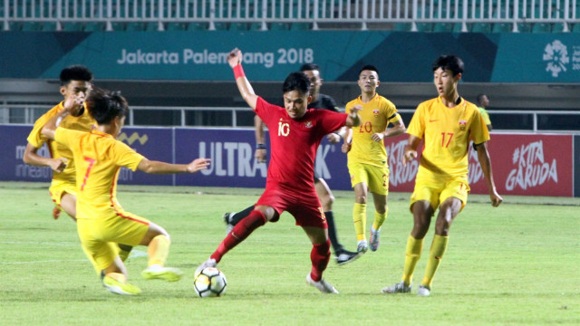 Pemain Timnas U-19, Witan Sulaeman, melewati adangan pemain-pemain Timnas China U-19. (Foto: ANTARA/Hafidz Mubarak A.)