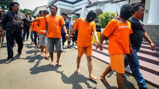Terduga pelaku penganiayaan terhadap seorang pendukung klub sepak bola berjalan menuju ruang tahanan usai ditunjukan kepada awak media di Polrestabes Bandung, Jawa Barat, Senin (24/9). (Foto: ANTARA FOTO/Prabu Kencana)