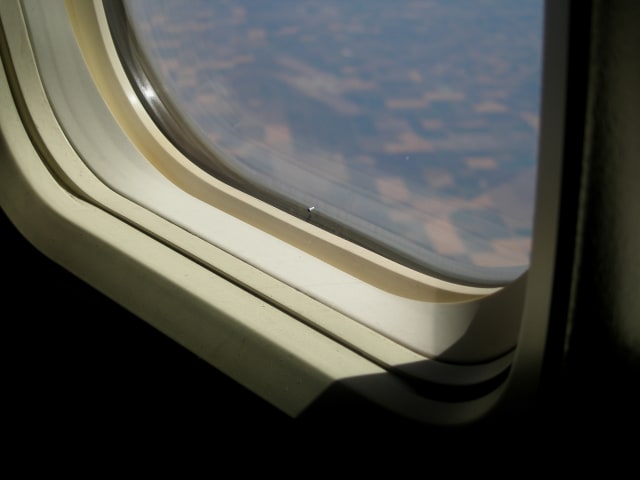 Lubang Kecil di Bagian Bawah Jendela Pesawat (Foto: Flickr / xina)