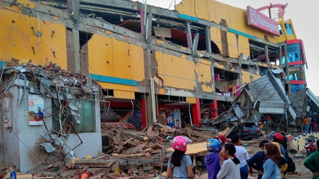 Warga melihat bangunan pusat perbelanjaan yang ambruk akibat gempa di Palu, Sulawesi Tengah, Sabtu (29/9). (Foto: ANTARA FOTO/Rolex Malaha)