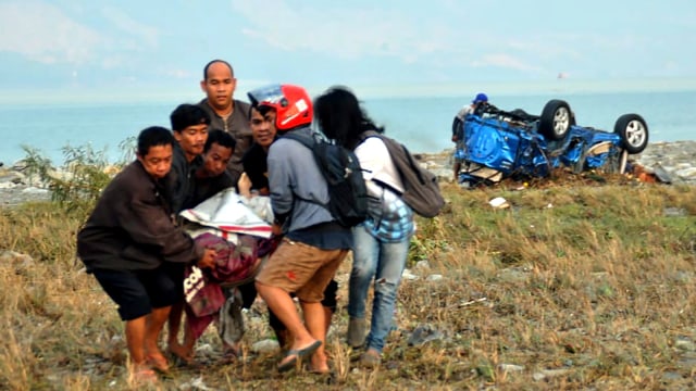 Evakuasi korban gempa bumi di Palu. (Foto: AFP/MUHAMMAD RIFKI)