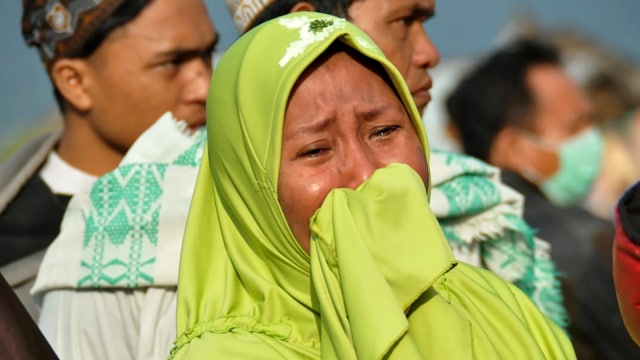 Seorang wanita yang menangis di lokasi gempa dan tsunami di Palu. (Foto: AFP/MUHAMMAD RIFKI)