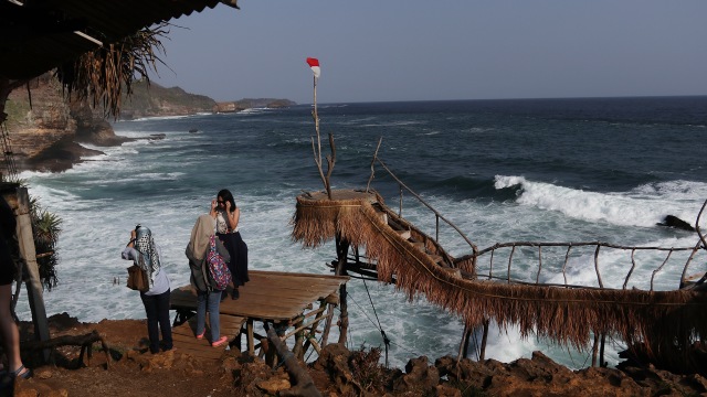 Pengunjung yang sedang mengabadikan momen di Pantai Timang. (Foto: Gitario Vista Inasis/kumparan)