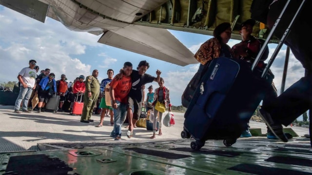 Warga terdampak gempa dan tsunami menunggu masuk ke dalam pesawat untuk dievakuasi di Palu, Sulawesi Tengah, Sabtu (29/9). (Foto: Antara/Muhammad Adimaja)