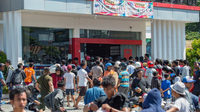 Warga menjarah toko swalayan di Palu, Sulawesi Tengah, pada 30 September 2018. (Foto: AFP/ BAY ISMOYO)