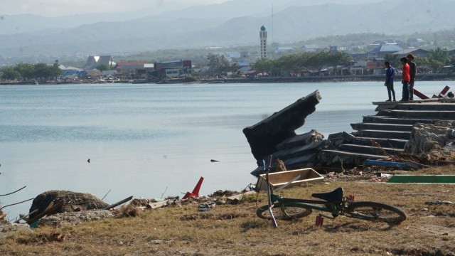 Warga berdiri di Pesisir Talise yang hancur akibat gempa bumi dan Tsunami, Palu, Sulawesi Tengah. (Foto: Jamal Ramadhan/kumparan)