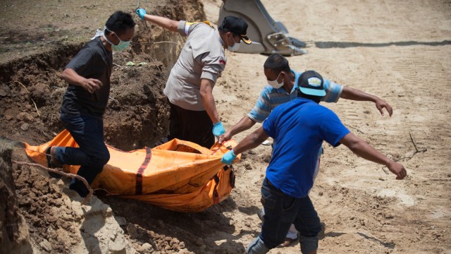 Proses pemakaman masal jenazah korban gempa dan tsunami di Palu, Sulawesi Tengah. (Foto: AFP/BAY ISMOYO)