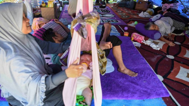 Pengungsi berisitirahat di tenda pengungsian di Lapangan Vatulemo, Palu, Sulawesi Tengah, Selasa (2/10). (Foto: ANTARA FOTO/Hafidz Mubarak A)