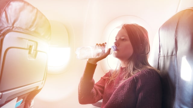 Ilustrasi minum dalam pesawat (Foto: Shutter Stock)