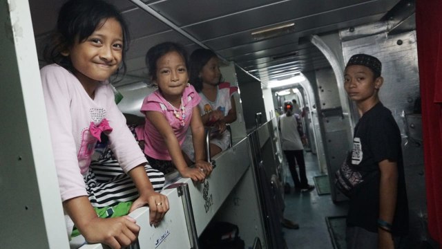 Sejumlah anak korban gempa bumi dan tsunami palu menaiki kapal KRI Makassar-590 untuk dievakuasi ke Makassar. (Foto: Jamal Ramadhan/kumparan)