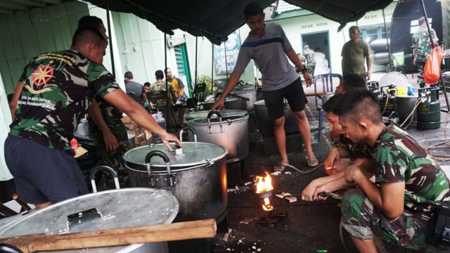 Sejumlah anggota TNI sibuk menyiapkan makanan untuk sarapan di dapur umum Korem 132, Jl. Jend. Sudirman, Palu, Kamis (4/10). (Foto: Jamal Ramadhan/kumparan)