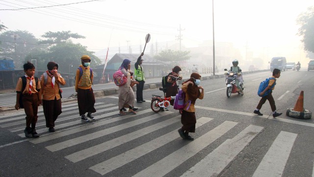 Sejumlah siswa dengan mengenakan masker melintasi zebra cross di Banjarbaru, Kalimantan Selatan, Sabtu (29/9).  Foto:  ANTARA FOTO/Ibay