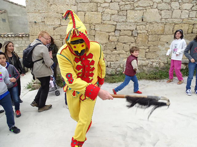 Pria Dengan Kostum Kuning dan Merah yang Bertugas Melompati Bayi (Foto: Flickr / Zooming Travel Spain)