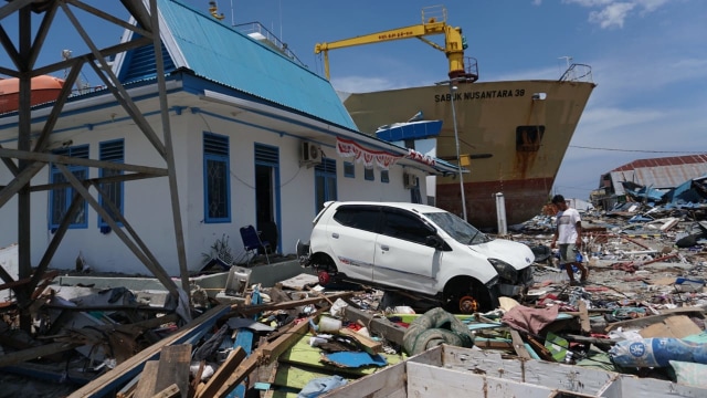 Warga di antara puing bangunan yang hancur pasca tsunami di Palu. (Foto: Jamal Ramadhan/kumparan)