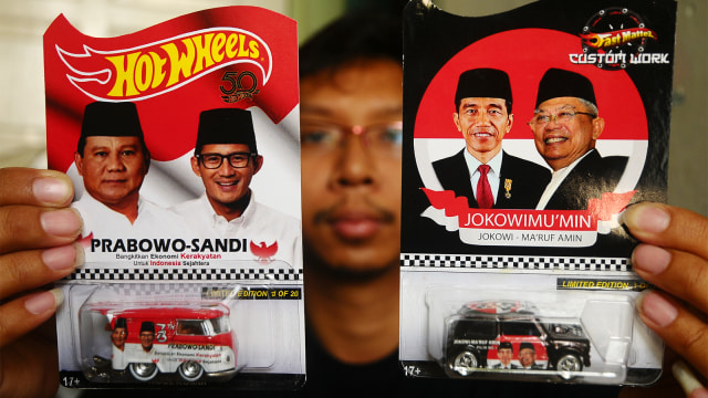 Perajin menunjukkan mobil mainan yang dimodifikasi bergambar pasangan calon presiden di desa Singocandi, Kudus, Jawa Tengah. (Foto: ANTARA FOTO/Yusuf Nugroho)