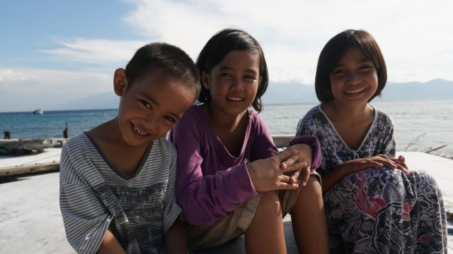 Putri Ramadhani (kiri), Nur Nissa (tengah) dan Ainun Naziah (kanan) di depan Masjid Al-Amiin, Kab. Donggala, Sulawesi Tengah, Jumat (5/10). (Foto: Jamal Ramadhan/kumparan )