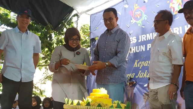 Gubernur DKI Jakarta Anies Baswedan memotong tumpeng di acara Kongres JRMK, Kampung Rawa, Kebon Jeruk, Jakarta Barat. (Foto: Maulana Ramadhan/kumparan)