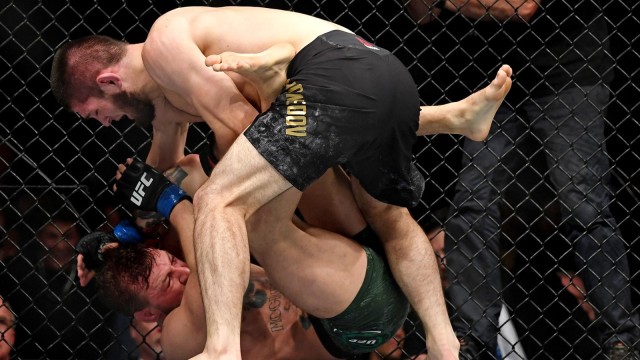 Khabib Nurmagomedov memukuli Conor McGregor yang tersungkur di ring. Foto: USA Today/Reuters/Stephen R. Sylvanie