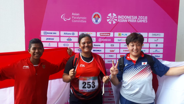 Suparniyati (tengah) persembahkan emas untuk Indonesia dari cabor para atletik nomor tolak peluru F20 putri. Tiwa (kiri) sumbang perunggu untuk Indonesia di nomor yang sama. (Foto: Karina Nur Shabrina/kumparan)