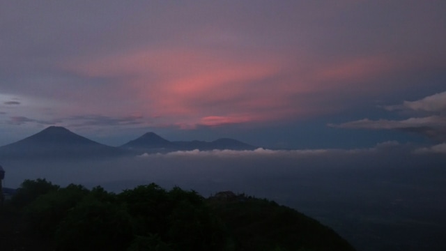 Gunung Sumbing dan Sindoro dilihat dari Puncak Andong saat matahari terbit Foto: Helinsa Rasputri/kumparan