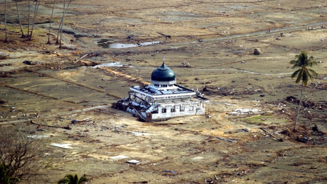 Sebuah masjid berdiri sendiri di antara daerah yang hancur di pantai Barat provinsi Aceh, (19/1/2005).  Foto: AFP PHOTO / Adek Berry