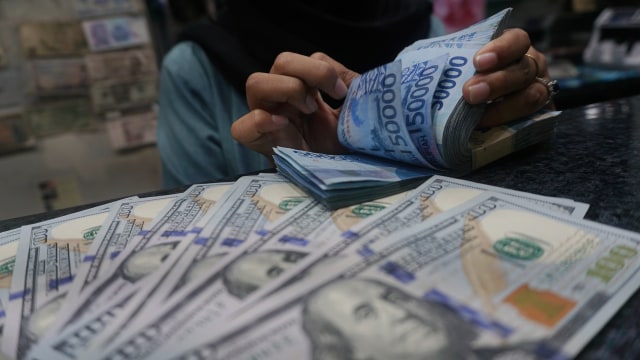 Petugas memperlihatkan pecahan uang dolar dan rupiah di salah satu tempat penukaran mata uang asing/money changer di Jakarta. (Foto: Fanny Kusumawardhani/kumparan)