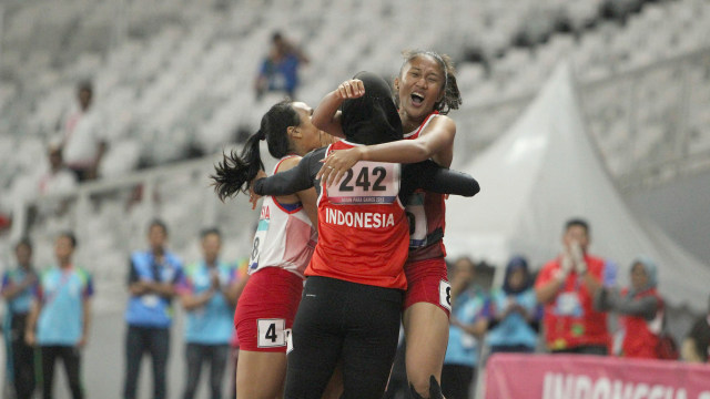 Ni Made Arianti (kiri) bersama Endang Sari Sitorus (tengah) dan Putri Aulia (kanan) merayakan kemenangan di final lari 100 meter putri T13. (Foto: The Jakarta Post Images: TJPimages/Charisa Vanessa G/Don/18))