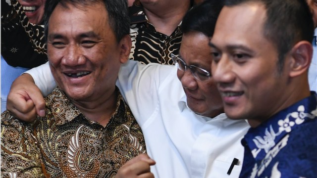Capres Prabowo Subianto (tengah) berpelukan dengan Wasekjen Partai Demokrat Andi Arief (kiri) disaksikan Komandan Satuan Tugas Bersama Partai Demokrat Agus Harimuri Yudhoyono (kanan) usai melakukan pertemuan di kediaman Susilo Bambang Yudhoyono di Kuningan, Jakarta, Rabu (12/9/2018).  (Foto: ANTARA FOTO/Hafidz Mubarak A)