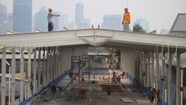 Pekerja menyelesaikan proyek Jembatan Penyeberangan Multiguna (Skybridge) Tanah Abang di Jakarta, Minggu (14/10). (Foto: ANTARA FOTO/Reno Esnir)