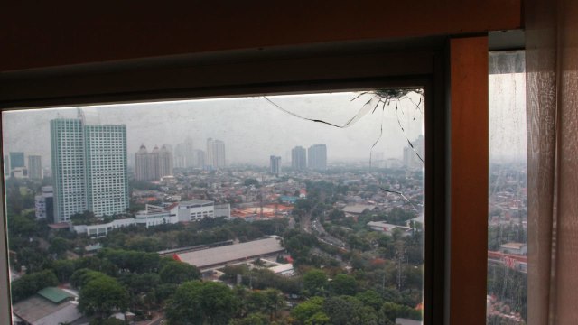 Retakan kaca jendela di lantai 20 ruang 20.03 milik anggota Fraksi PAN Totok Daryanto diduga dari peluru nyasar dari lapangan tembak. (Foto: Helmi Afandi Abdullah/kumparan)