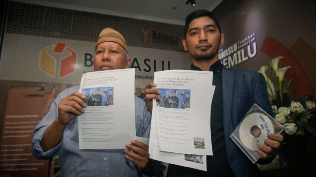 Advokat Dahlan Pido (kiri) dan M. Taufiqurrahman (kanan) yang bertindak sebagai masyarakat menunjukkan barang bukti saat melapor ke Bawaslu terkait dugaan keberpihakan Luhut Binsar Panjaitan dan Sri Mulyani. (Foto: Jamal Ramadhan/kumparan)