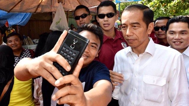Presiden Jokowi foto bersama dengan salah satu pedagang di Pasar Karangayu, Semarang, Jawa Tengah. (Foto: Dok.  Agus Suparto/Presidential Palace)
