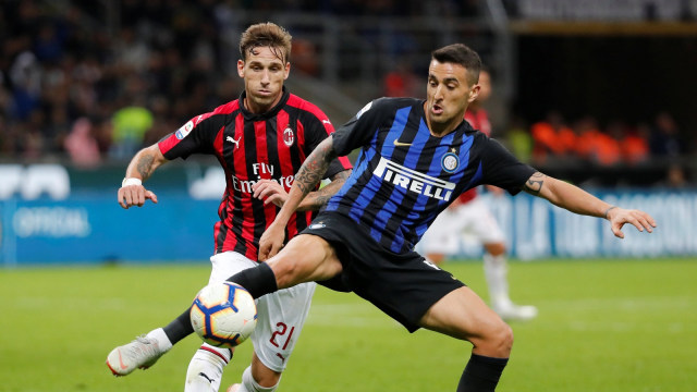 Matias Vecino berduel dengan pemain Milan. (Foto: REUTERS/Stefano Rellandini)