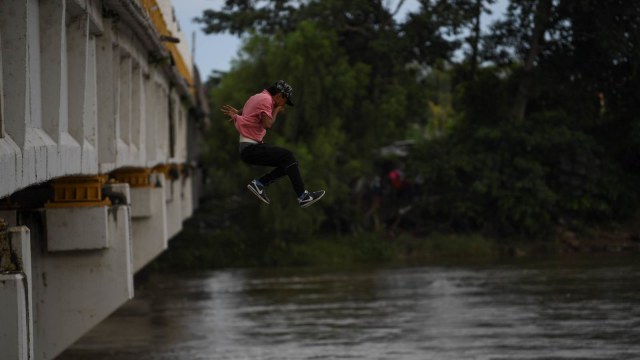 Seorang Migran Terjun Dari Jembatan Perbatasan Guatemala-Meksiko. (Foto: AFP/Pedro Pardo)